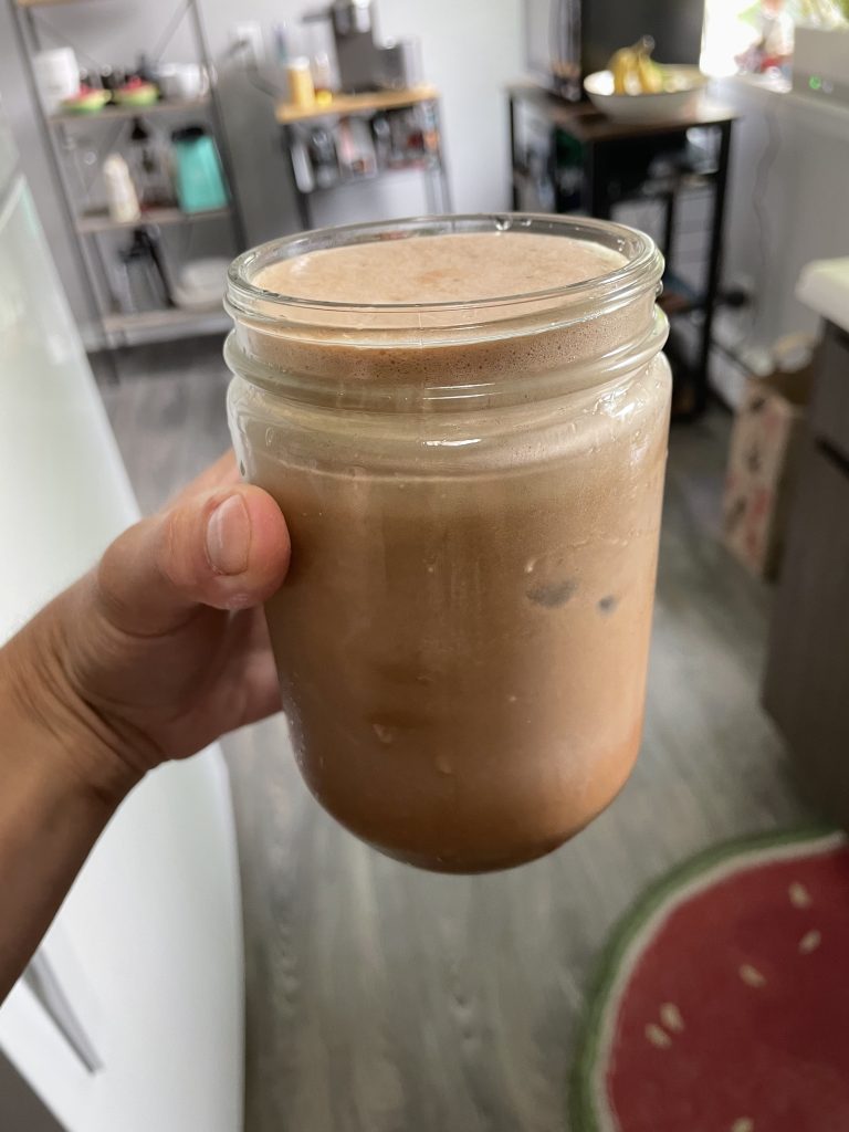Hand holding a cup of iced maple mocha latte